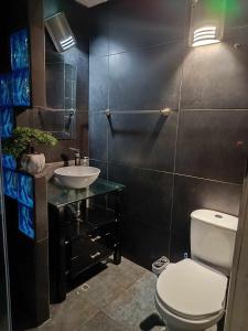 a bathroom with a white toilet and a sink at casa en el norte de la ciudad, a 5 minutos del portal norte in Bogotá