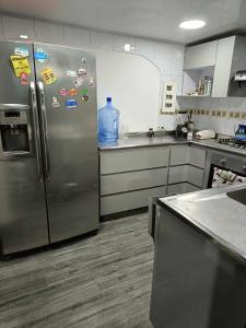 a kitchen with a stainless steel refrigerator with magnets at casa en el norte de la ciudad, a 5 minutos del portal norte in Bogotá