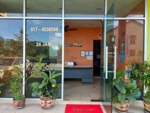 einer Eingangstür eines Gebäudes mit Topfpflanzen in der Unterkunft TGT MOTEL Gurun in Kampung Gurun