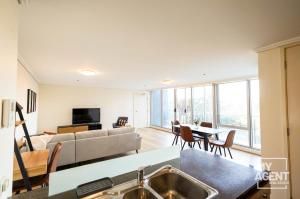een woonkamer met een bank en een tafel bij Spacious Apartment in Southbank - Sleeps 6 in Melbourne
