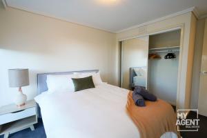 een slaapkamer met een groot wit bed en een spiegel bij Spacious Apartment in Southbank - Sleeps 6 in Melbourne