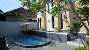 a swimming pool in the backyard of a house at Villa Jogja Grand Bale with Private Pool by Simply Homy in Yogyakarta
