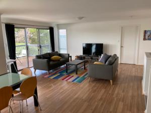 a living room with two couches and a table at Bay views on Laurie in Encounter Bay