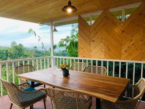 a wooden table and chairs on a porch at Strawberry Guyabano Farm in Kabalen