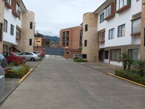 uma rua vazia num parque de estacionamento com edifícios em Departamento Duplex con Terraza em Cuenca