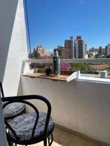une chaise sur un balcon avec vue sur la ville dans l'établissement Excelente apartamento equipado céntrico, à Corrientes