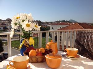 a table with a basket of fruit and a vase with flowers at Hotel Alex in Methoni