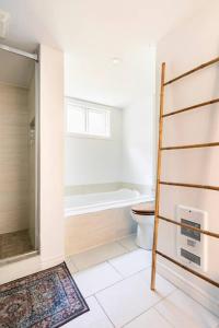a bathroom with a toilet and a bath tub at Bright Riverfront 3-Bedroom Condo in Montréal