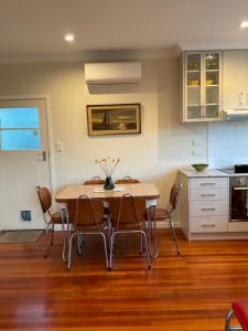 eine Küche mit einem Esstisch und Stühlen in der Unterkunft Refined, Retro & Relaxing in Paraparaumu