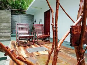 two chairs and a table on a wooden deck at ELLA Delightful Surround in Ella