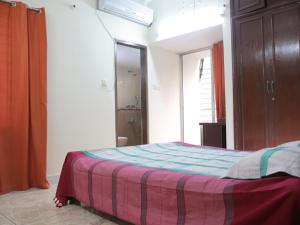 a bedroom with a bed with a striped blanket at Golpata Bed & Breakfast in Dhaka