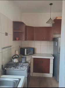 a small kitchen with a stove and a sink at Departamento para 3 personas in Cochabamba