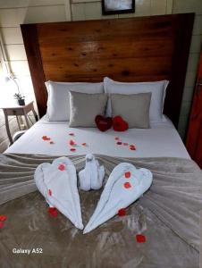 - un lit avec deux vêtements et des fleurs dans l'établissement Sitio do Sol suíte romântica, à Guabiruba