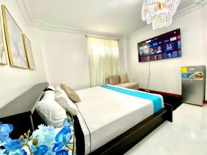 ein Schlafzimmer mit einem Bett und einem TV an der Wand in der Unterkunft Habitacion Master a cinco minutos del aeropuerto in Guayaquil