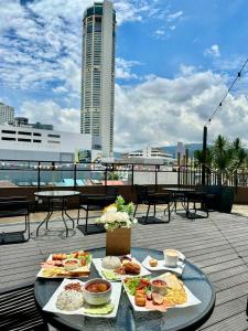 una mesa con platos de comida en la azotea en Le Dream Boutique Hotel en George Town