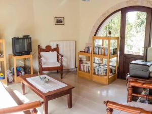 a living room filled with furniture and a tv at Group Accomodation, Heliopetra Studios And Houses in Douliana