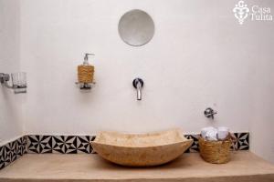 a bathroom with a stone sink and a mirror at Casa Tulita Valladolid in Valladolid +63 photos