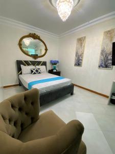 - une chambre avec un lit, une chaise et un miroir dans l'établissement HABITACION CON BAÑO COMPARTIDO, à Guayaquil