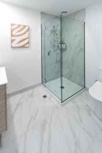 a bathroom with a glass shower and a toilet at Central Charm 2 bed 2 bath w/ sunny Balcony in Christchurch