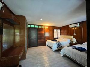 a hotel room with two beds and a desk at ALUN ALUN ISLAND RESORT in Kampong Atap Zing