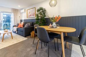 a living room with a table and chairs and a couch at Central Charm 2 bed 2 bath w/ sunny Balcony in Christchurch +40 photos
