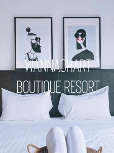 a person laying on a bed with two pictures on the wall at Wannachart Boutique Resort in Tha Sala