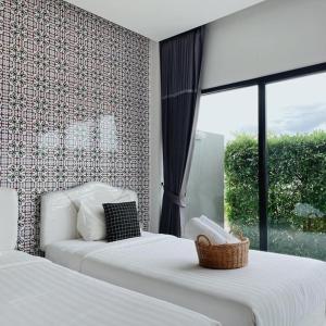 1 dormitorio con 2 camas y ventana en Wannachart Boutique Resort, en Tha Sala