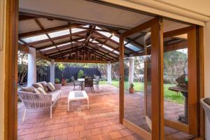 a patio with a wooden pergola at Lake Edge Retreat in Quindalup