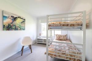 a room with a bunk bed and a chair at Lake Edge Retreat in Quindalup