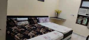 a bedroom with a bed with a black and white comforter at Brijlok Dham homestay in Mathura