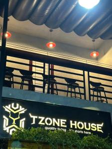 a sign for a tzone house with chairs and lights at T Zone Hostel in Ho Chi Minh City