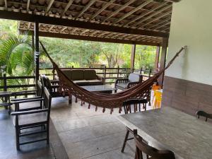 a hammock on a patio with a table and chairs at Chacara Maluco Beleza 2 in Gravatá