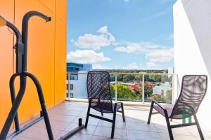 2 sillas sentadas en un balcón con vistas en Homebush EventHub Contemporary 2B2B Apt, en Sídney