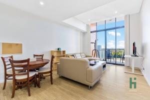 sala de estar con mesa, sofá y comedor en Homebush EventHub Contemporary 2B2B Apt, en Sídney
