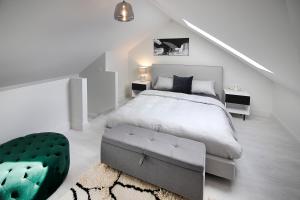 OhauitiにあるHillbrook - a luxurious designer houseの白いベッドルーム(ベッド1台、緑のオットマン付)