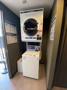福岡的住宿－Hotel STARRIZE，客房内的洗衣机和烘干机