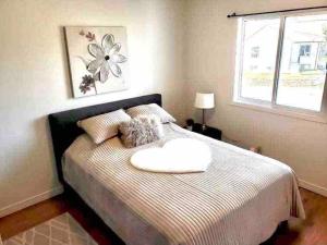 a bedroom with a bed with a pillow on it at Furnished Townhouse w parking by Hospital & University! in Thunder Bay