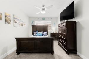 a bedroom with a bed and a dresser with a ceiling fan at The Texas Pearl in Corpus Christi