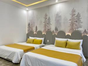 a room with two beds with yellow pillows at Letters Bà Triệu in Liên Trì (3)