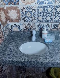 um balcão de casa de banho com um lavatório branco em Hospedaserra em Tiradentes