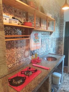 a kitchen with a stove top and a sink at Hospedaserra in Tiradentes