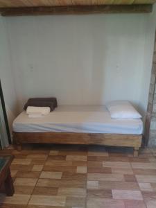 a bed in a room with a wooden frame at Hospedaserra in Tiradentes +2 photos