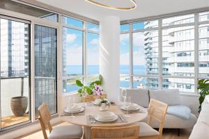 comedor con mesa, sillas y ventanas en Lakefront Retreat: Designer Suite w/Stunning Views, en Toronto