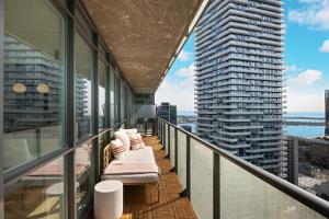 a balcony with a view of two tall buildings at Lakefront Retreat: Designer Suite w/Stunning Views in Toronto