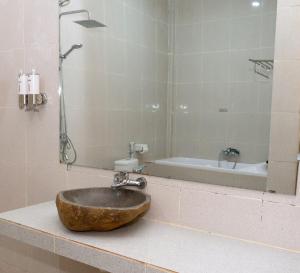 a bathroom with a sink with a shower and a tub at Green Prundi Hotel in Labuan Bajo