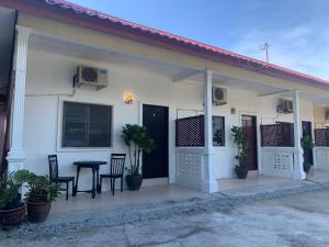 a white house with a table and chairs in front of it at Rerama Room Stay Langkawi in Pantai Cenang