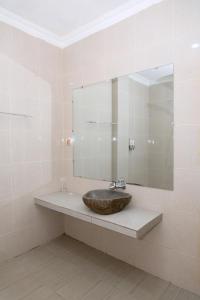 baño con lavabo y espejo grande en Green Prundi Hotel, en Labuan Bajo