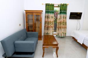 ラブハン・バジョにあるGreen Prundi Hotelのリビングルーム(青いソファ、テーブル付)
