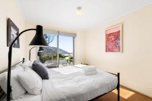 a bedroom with a white bed and a window at Altair in Wye River