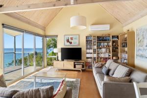 a living room with a couch and a tv at Altair in Wye River